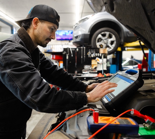 Car Doctors Auto Technician running diagnostics on a vehicle in our garage.